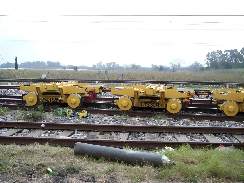 Rail track trolley units on railway tracks for equipment transport.