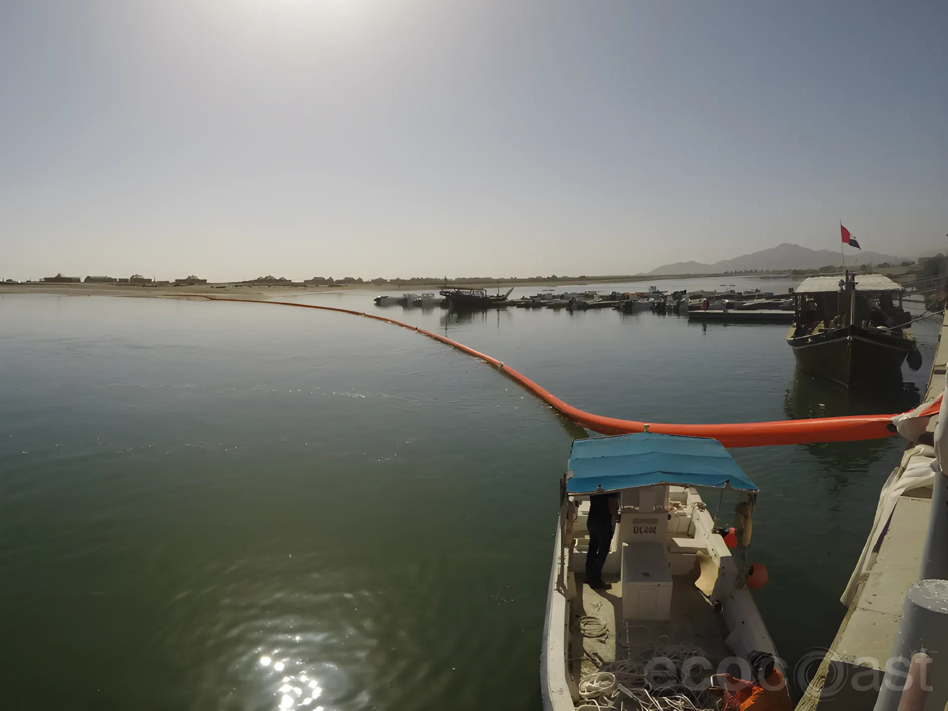 Inflatable oil boom around harbor boats