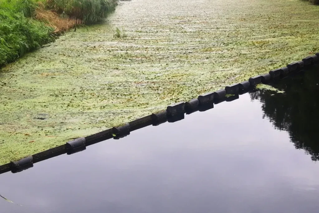 Floating debris barrier controlling vegetation and floating debris in a waterway