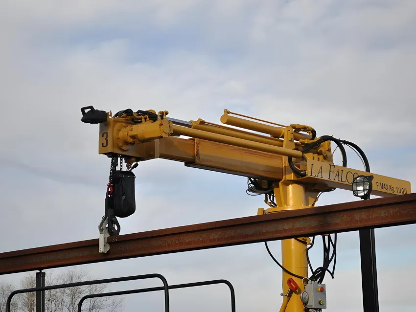 Close up of a rails loader crane lifting a long rail section for railway track construction