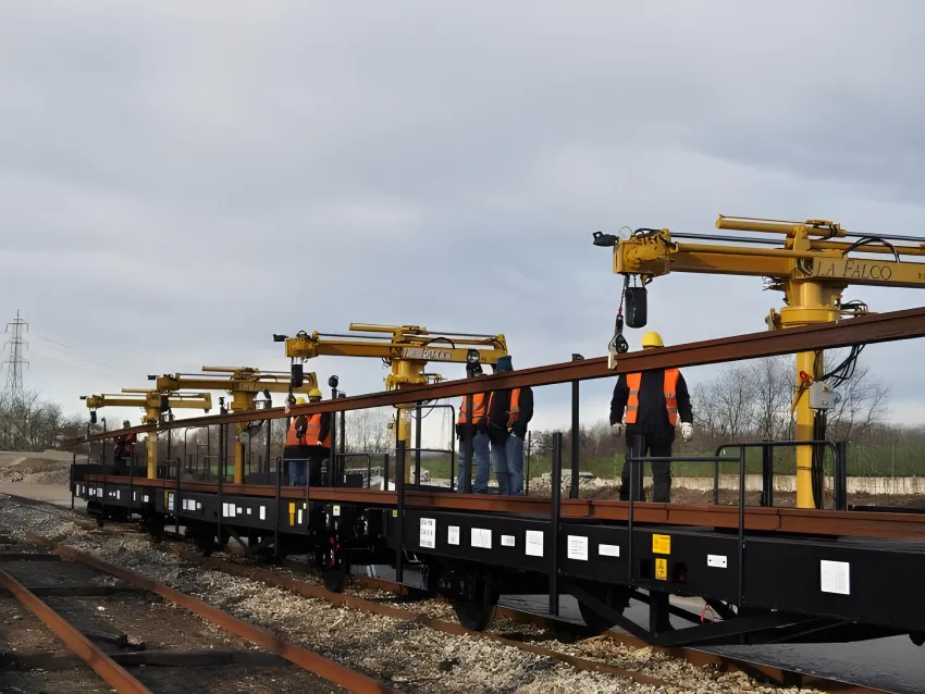 Rails loader crane system carrying long rail sections for railway construction and track maintenance